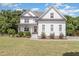 Beautiful two-story white farmhouse-style home with well-maintained lawn and landscaping creating a welcoming curb appeal at 5180 Old Powell Rd, Holly Springs, NC 27540