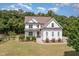 Stunning aerial view of this two-story white farmhouse-style home showcasing lush landscaping and a spacious lawn at 5180 Old Powell Rd, Holly Springs, NC 27540