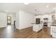 Open-concept kitchen features a large island, stainless steel appliances, and stylish pendant lighting at 5180 Old Powell Rd, Holly Springs, NC 27540