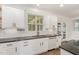 Bright kitchen features white cabinets, black countertops, stainless steel sink, and access to the backyard at 5180 Old Powell Rd, Holly Springs, NC 27540