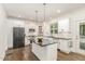 Modern kitchen features white cabinetry, a center island, stainless steel appliances, and stylish accents at 5180 Old Powell Rd, Holly Springs, NC 27540