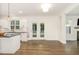Bright kitchen with an island, black countertops, white cabinets, and French doors to the backyard at 5180 Old Powell Rd, Holly Springs, NC 27540
