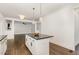 Open-concept kitchen features a center island with stylish pendant lights and white cabinets at 5180 Old Powell Rd, Holly Springs, NC 27540