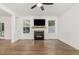 Bright living room with fireplace, large windows, and hardwood floors throughout, is shown at 5180 Old Powell Rd, Holly Springs, NC 27540