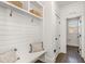 Bright mudroom features built-in storage cubbies and bench seating with shiplap accents and hooks at 5180 Old Powell Rd, Holly Springs, NC 27540