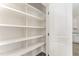 Large walk-in pantry with ample shelving for organized storage is showcased in the home at 5180 Old Powell Rd, Holly Springs, NC 27540