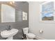 Stylish powder room featuring shiplap accent wall, elegant mirror, and natural light from the window at 5180 Old Powell Rd, Holly Springs, NC 27540