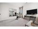 Bright living room featuring neutral walls, large TV, and exercise bicycle at 55 E American Marigold Dr # 36, Benson, NC 27504