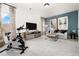Bright living room featuring neutral walls, large TV, and exercise bicycle at 55 E American Marigold Dr # 36, Benson, NC 27504