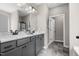 Well-lit main bathroom with double sink vanity, marble countertop, gray cabinets, and gray tile flooring at 55 E American Marigold Dr # 36, Benson, NC 27504