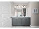 Bright main bathroom featuring double sink vanity, marble countertop, gray cabinets, and contemporary lighting at 55 E American Marigold Dr # 36, Benson, NC 27504