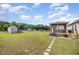Large, well-maintained backyard with a screened-in porch, storage shed, and a lush green lawn at 59 Long Grass Dr, Smithfield, NC 27577
