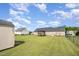 Expansive backyard showcasing a screened porch, manicured lawn, fenced perimeter, and storage shed at 59 Long Grass Dr, Smithfield, NC 27577