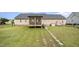 Spacious backyard featuring a screened porch, lush green grass, and a charming stone pathway at 59 Long Grass Dr, Smithfield, NC 27577