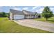 Charming home exterior featuring a two-car garage, covered porch, and a well-manicured lawn at 59 Long Grass Dr, Smithfield, NC 27577