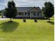 Charming single-story home featuring a covered porch and a well-manicured lawn with mature trees and landscaped features at 59 Long Grass Dr, Smithfield, NC 27577