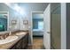 Bathroom featuring a double vanity sink, walk-in shower, and blue walls with views of the bedroom at 5912 Mt Zion Rd, Snow Camp, NC 27349