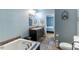 Bathroom featuring a soaking tub, double vanity sinks, and blue walls with views of the bedroom at 5912 Mt Zion Rd, Snow Camp, NC 27349
