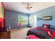 Bedroom featuring blue walls, fan, window views, and bed with Mario themed bedding at 5912 Mt Zion Rd, Snow Camp, NC 27349