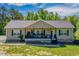 Inviting one-story home with black shutters, a porch with rocking chairs, and brick trim at 5912 Mt Zion Rd, Snow Camp, NC 27349