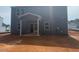 View of the backyard showing a gray, two-story home with a covered patio at 6828 Galloway Dr, Middlesex, NC 27557