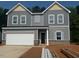 Charming two-story home with gray siding, a two-car garage, and a well-manicured lawn at 6828 Galloway Dr, Middlesex, NC 27557