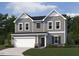 Charming two-story home with gray siding, white trim, and a two-car garage on a well manicured lawn at 6828 Galloway Dr, Middlesex, NC 27557