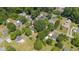 An aerial view showcases a property surrounded by lush trees and well-maintained lawns in a serene neighborhood setting at 701 Veterans Dr, Elon, NC 27244