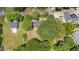 Aerial view showcasing a charming home nestled among mature trees in a serene, residential area at 701 Veterans Dr, Elon, NC 27244