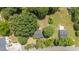 Aerial view showcasing a charming home nestled among mature trees in a serene, residential area at 701 Veterans Dr, Elon, NC 27244