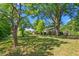 Lush backyard with mature trees, outbuilding, and a level lawn at 701 Veterans Dr, Elon, NC 27244