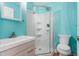 Bright bathroom featuring a glass door shower, modern vanity, and blue walls at 701 Veterans Dr, Elon, NC 27244