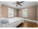 Comfortable bedroom with hardwood floors, ample natural light, and a ceiling fan at 701 Veterans Dr, Elon, NC 27244