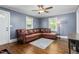 Inviting living room featuring hardwood floors, a leather sectional, and natural light at 701 Veterans Dr, Elon, NC 27244
