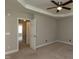 Bedroom with tray ceiling, carpet flooring and view of en-suite bathroom at 716 Lakeview Ave, Wake Forest, NC 27587