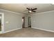 Neutral living room showcasing ceiling fan, carpet, and access to the exterior and kitchen at 716 Lakeview Ave, Wake Forest, NC 27587