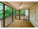 Covered screened porch with wood flooring and ceiling fan, perfect for outdoor relaxation at 716 Lakeview Ave, Wake Forest, NC 27587