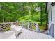 Relaxing white deck with two chairs, offering a serene outdoor space surrounded by lush trees at 823 Churchill Dr, Chapel Hill, NC 27517