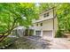 Exterior view of a white home with screened porch, lush greenery, and a two car garage at 823 Churchill Dr, Chapel Hill, NC 27517