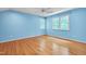Spacious bedroom with hardwood floors, light blue walls, and natural light from two windows at 823 Churchill Dr, Chapel Hill, NC 27517