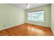 Well-lit bedroom featuring hardwood floors, a ceiling fan, and ample natural light at 823 Churchill Dr, Chapel Hill, NC 27517