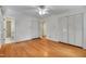 Bright bedroom features hardwood floors, a ceiling fan, and ample closet space for storage at 823 Churchill Dr, Chapel Hill, NC 27517