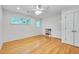Sunny bedroom featuring hardwood floors, built in shelving, and two large windows at 823 Churchill Dr, Chapel Hill, NC 27517