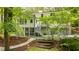 Backyard view of a white house with screened in porch, lush landscaping, stone pathway, and green lawn at 823 Churchill Dr, Chapel Hill, NC 27517
