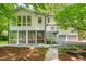 Charming white home featuring a screened porch, stairs, and a well-manicured backyard and a two car garage at 823 Churchill Dr, Chapel Hill, NC 27517