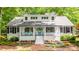 Beautifully renovated home showcasing a bright blue door, black shutters, and a brick pathway leading to the entrance at 823 Churchill Dr, Chapel Hill, NC 27517