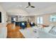 Open-concept living room and kitchen featuring hardwood floors, ceiling fan, and natural light at 823 Churchill Dr, Chapel Hill, NC 27517