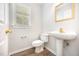 Charming powder room with pedestal sink, gold fixtures, and a window at 84 Sycamore Lake Rd, Siler City, NC 27344