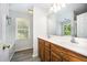 Bathroom featuring double sinks, wood cabinets, and natural light from the window at 84 Sycamore Lake Rd, Siler City, NC 27344
