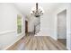 Open-concept dining room features a stylish chandelier and beautiful light wood-look flooring at 84 Sycamore Lake Rd, Siler City, NC 27344